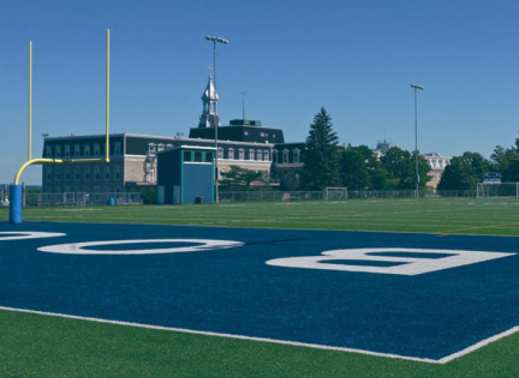 Image du Collège Bourget situé à flanc de montagne, avec un campus unique où les jeunes peuvent s'épanouir en toute sécurité, dont un magnifique terrain de football.